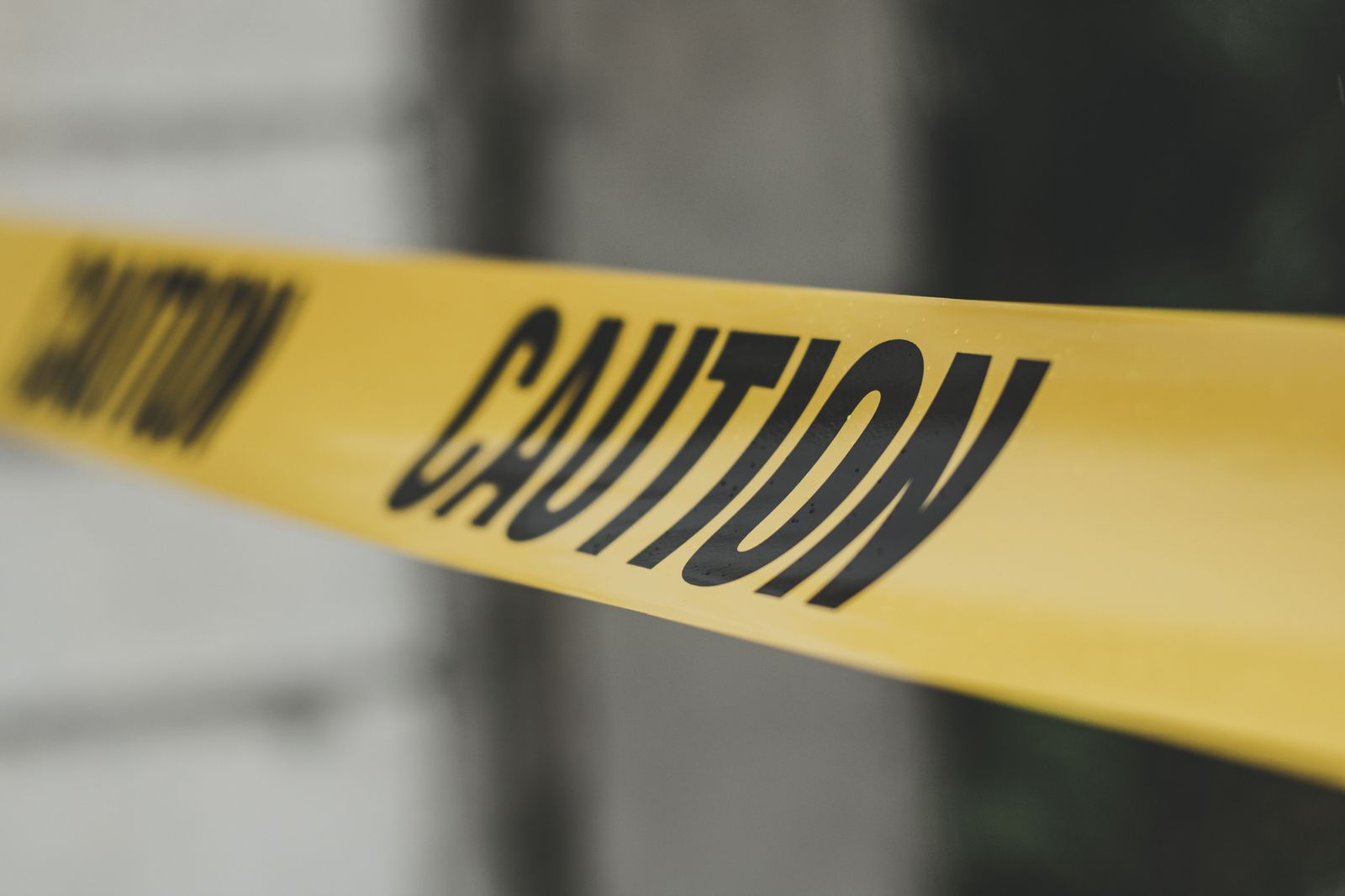 Yellow caution tape stretched across an outdoor area